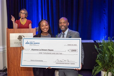 Commissioner Bakari F. Burns offering charitable check