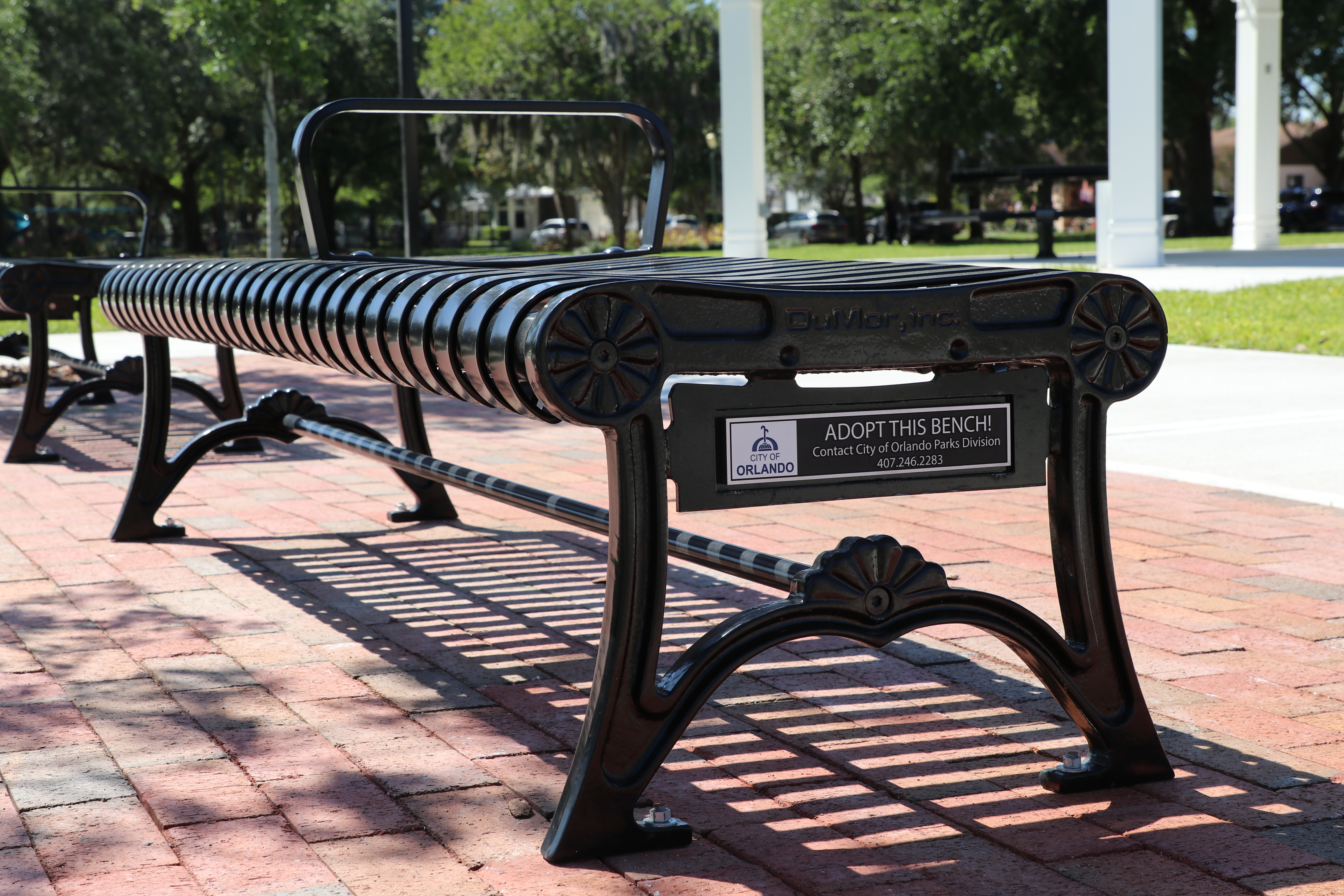 An example of the backless bench at a city park. The bench is black and has a commemoration plaque with room for a customized message.