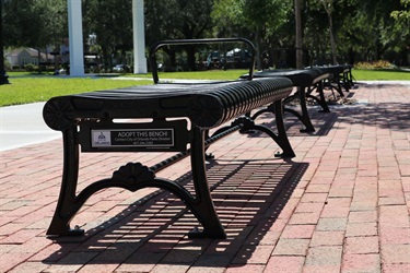 An example of a backless memorial bench at a city park, with a commemoration plaque for a customized message.